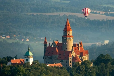 Pohled na hrad Bouzov s balonem Viktoria v pozadí